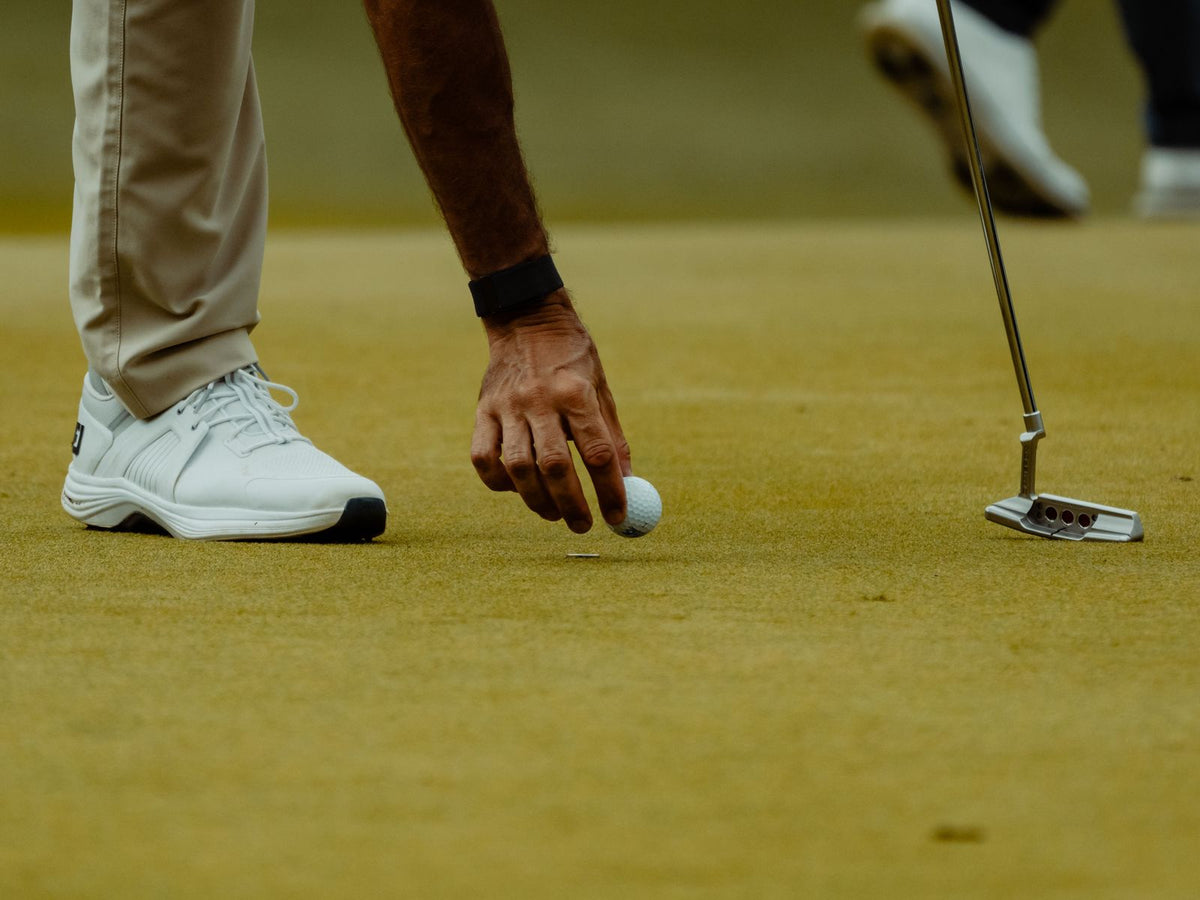 Golfeur qui replace sa balle sur le green, gros plan